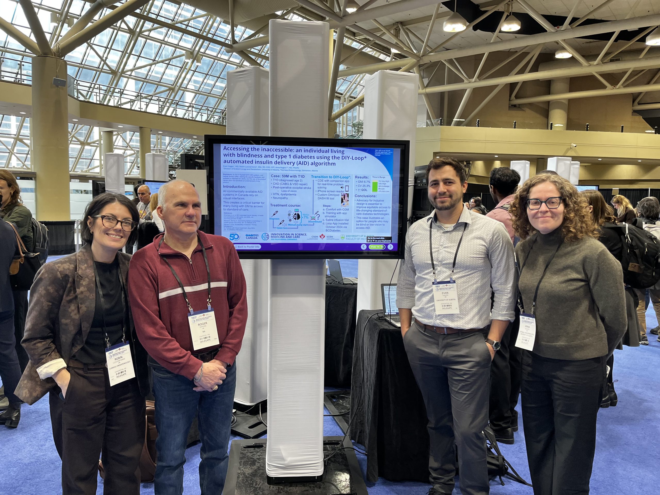 Clinical team standing beside their conference poster describing accessible AID for someone who is blind.